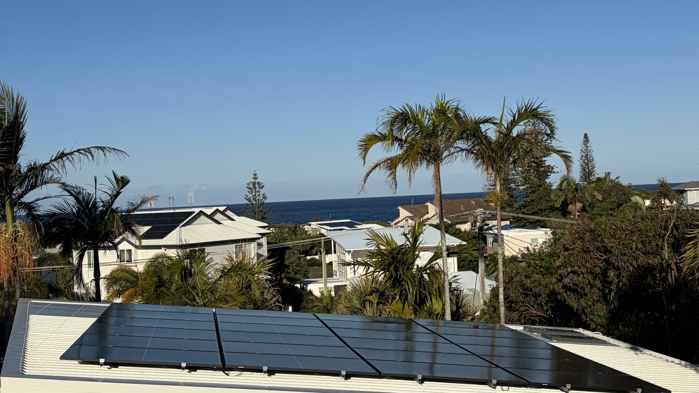 Solar array installed on a coastal Brisbane rooftop overlooking the ocean